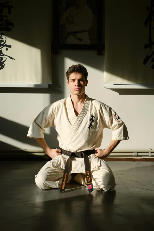 a man in karate uniform sitting on the ground