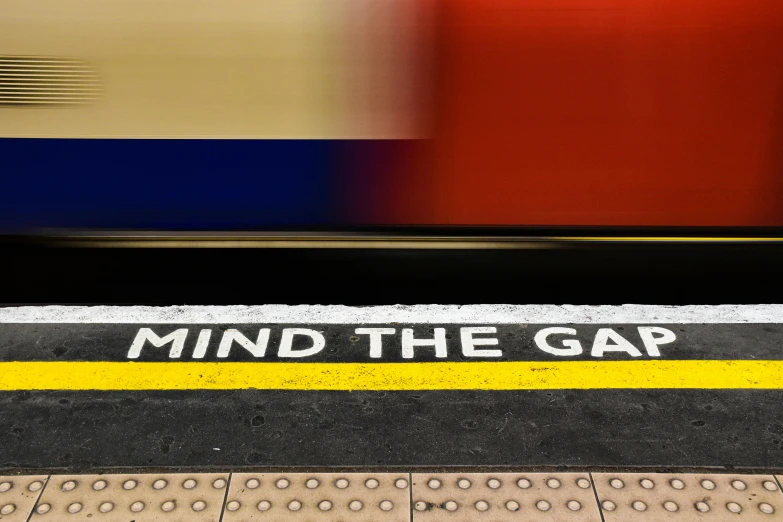 sign that reads mind the gap on a train platform