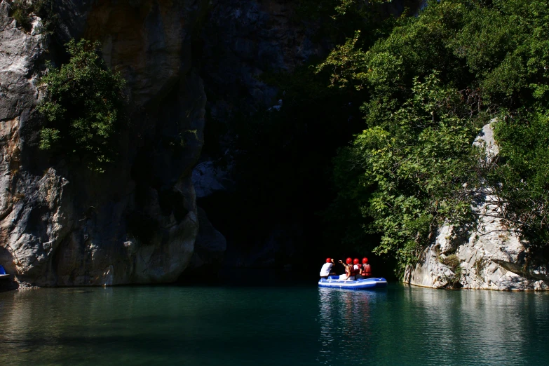 four red people wearing life jackets are on a raft