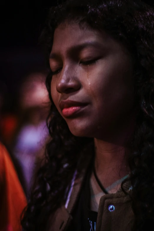 a woman with her eyes closed using her cell phone