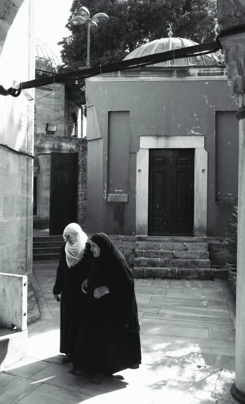 an old woman in black dress sitting on steps