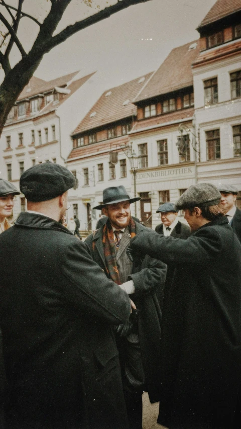 men talking and wearing coats in the middle of a city