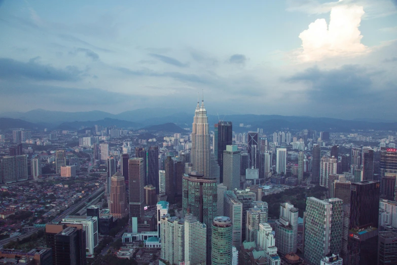 a city skyline with tall buildings under cloudy skies