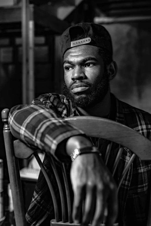 a black man with beard sitting in a chair