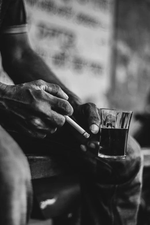 man with cigarette and cigarette lighter sitting at table