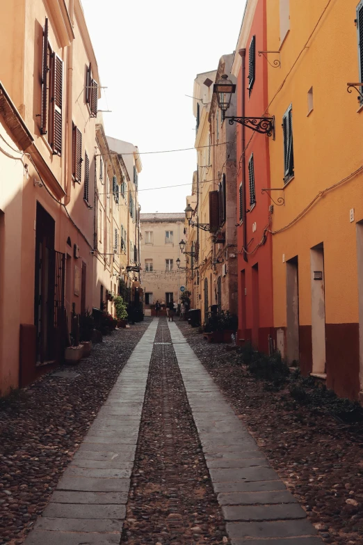 a walkway made of cobblestone between two buildings