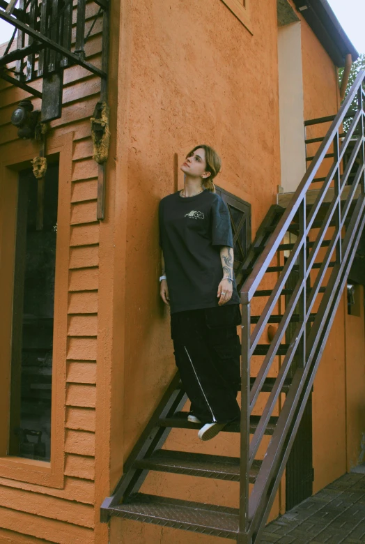 a man wearing black standing next to an apartment