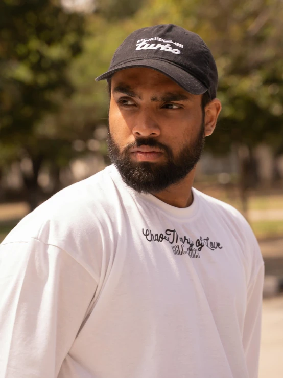 a bearded man is standing near the trees