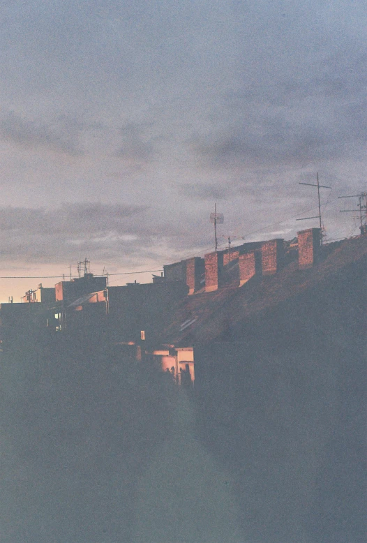 buildings sitting on top of a hill at dusk