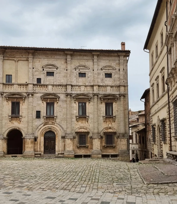 an empty street between two buildings with a clock on top