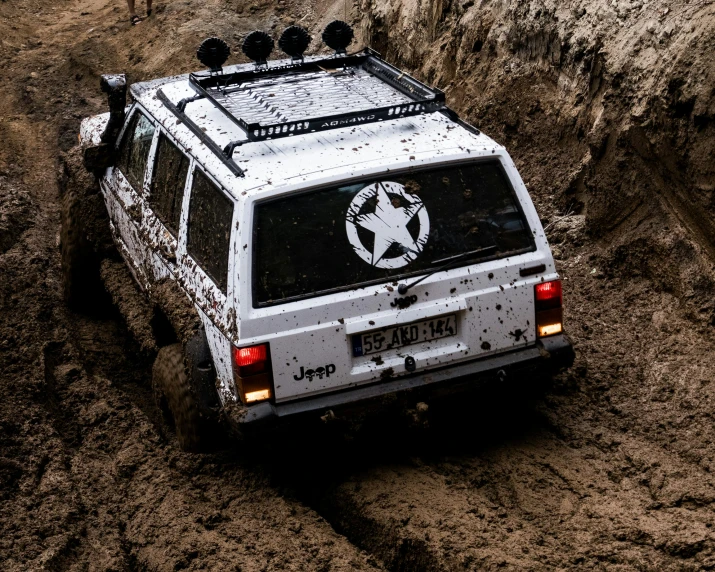 a vehicle is driving through mud on a dirt road