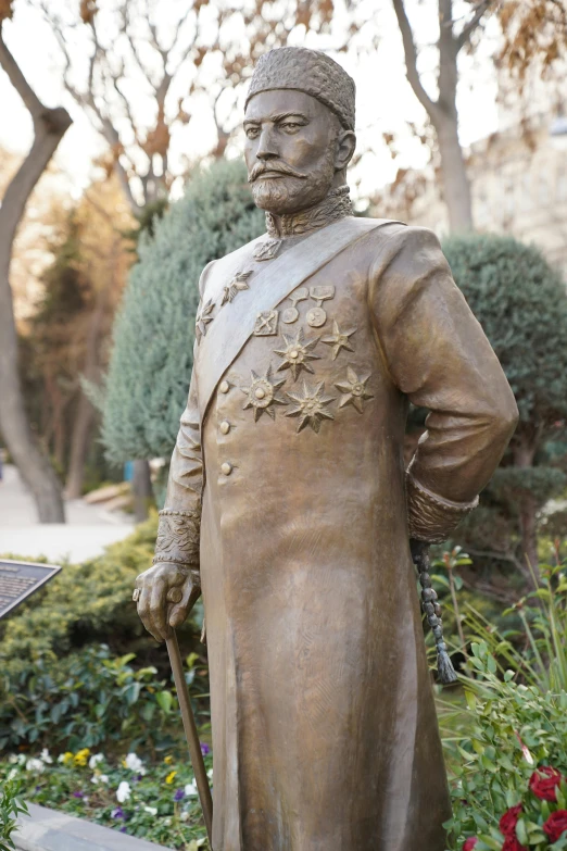 a statue is sitting in a flower garden