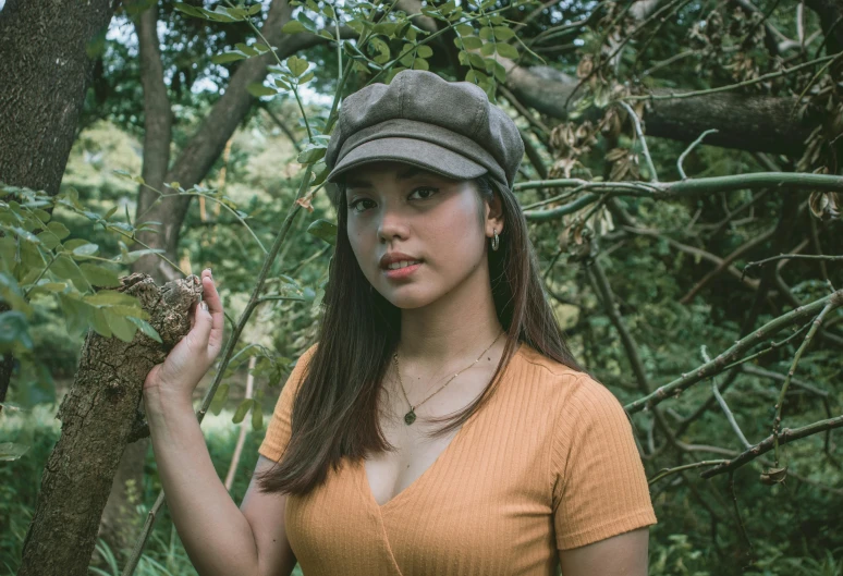 a girl wearing a hat while posing for the camera