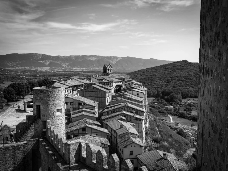 black and white pograph of buildings next to mountains