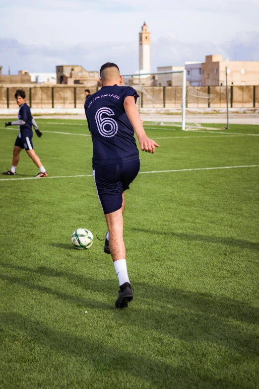 man on a soccer field kicking a ball