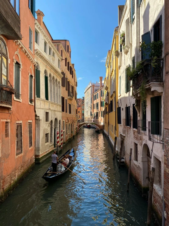 several gondola ride down a narrow canal through a residential area