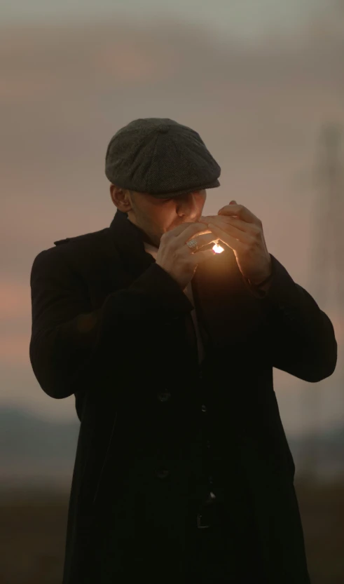 a man holding a lit candle is standing on the beach