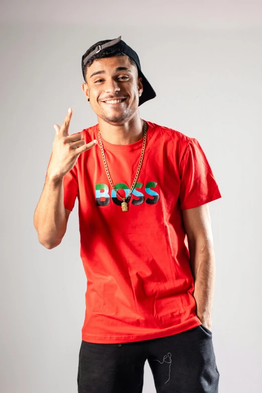 a man in red t - shirt with a hat and cigarette