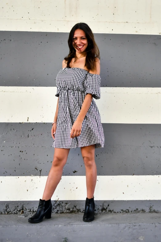 a woman is smiling while standing against a wall