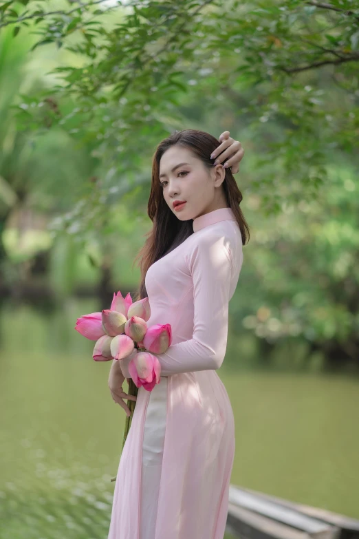 a woman in pink dress and white boots by flowers