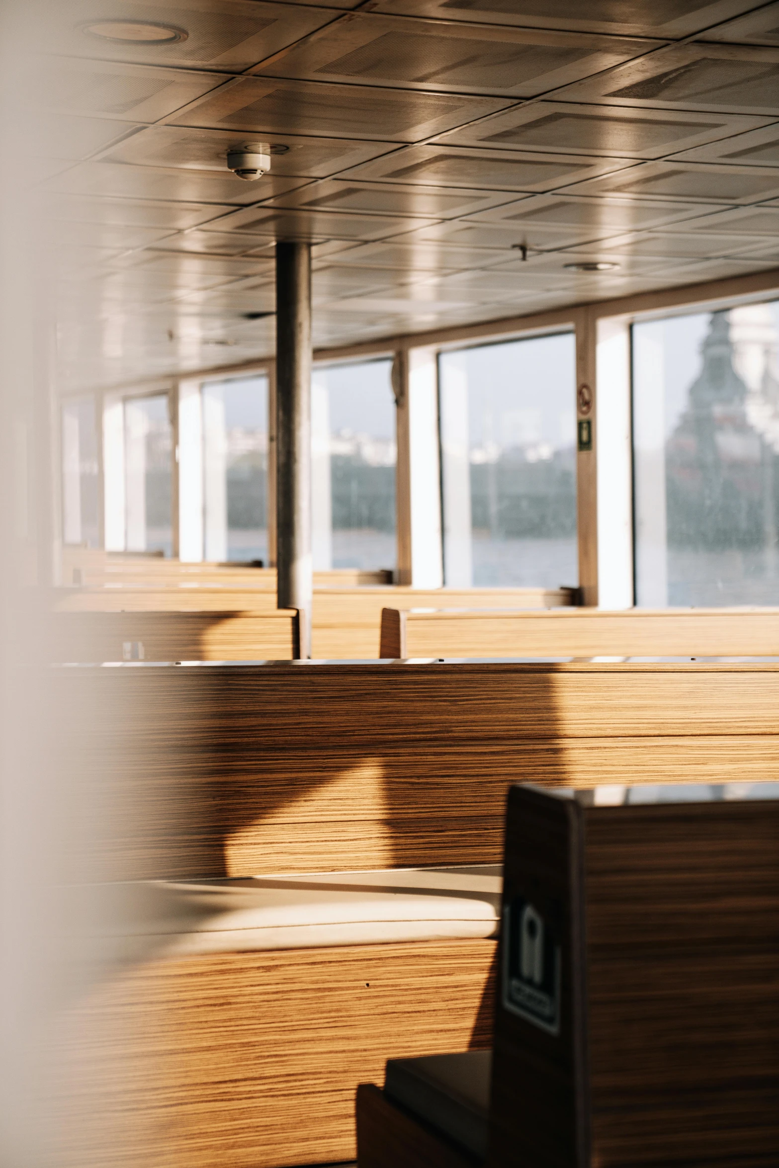 the empty benches are facing towards a window