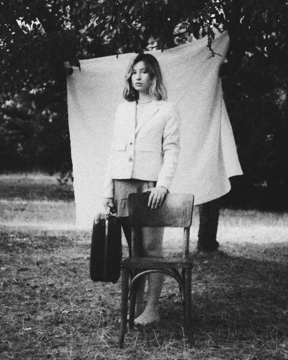 a woman wearing a jacket and skirt is holding an umbrella