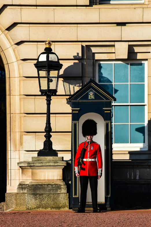 a guard in red jacket standing next to building