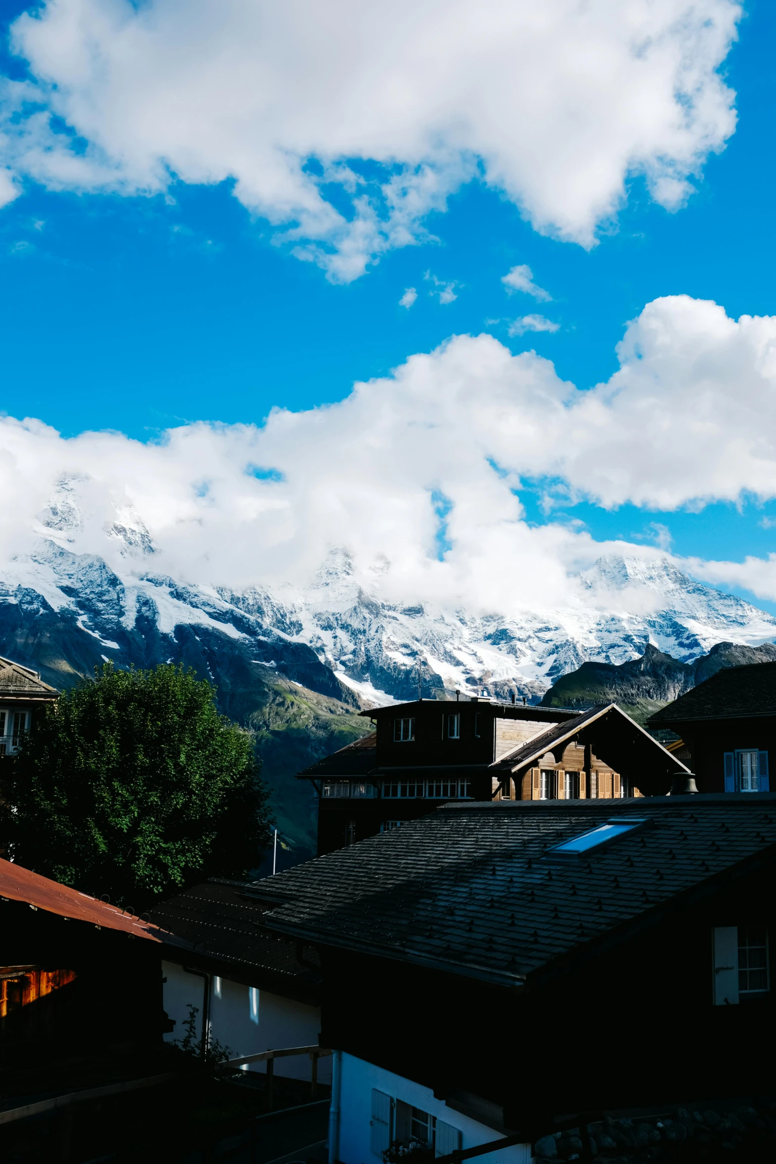 several tall buildings stand near the snow - capped mountains