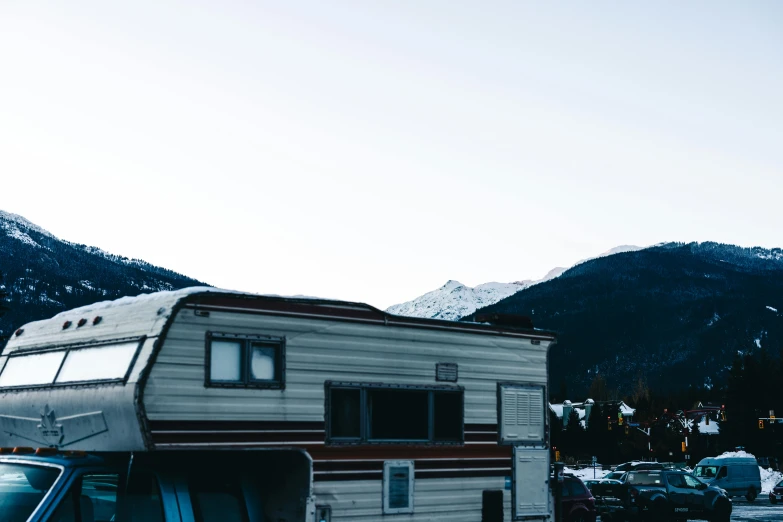 an old trailer is parked in front of mountains