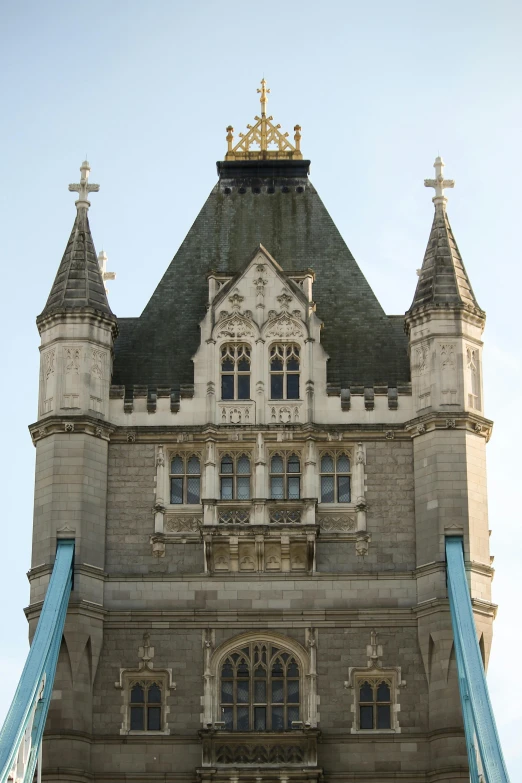 a castle structure with blue and silver ropes and a golden cross on top