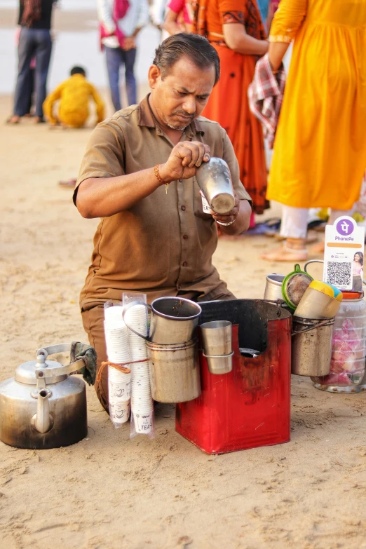 a man on the ground putting soing in a container