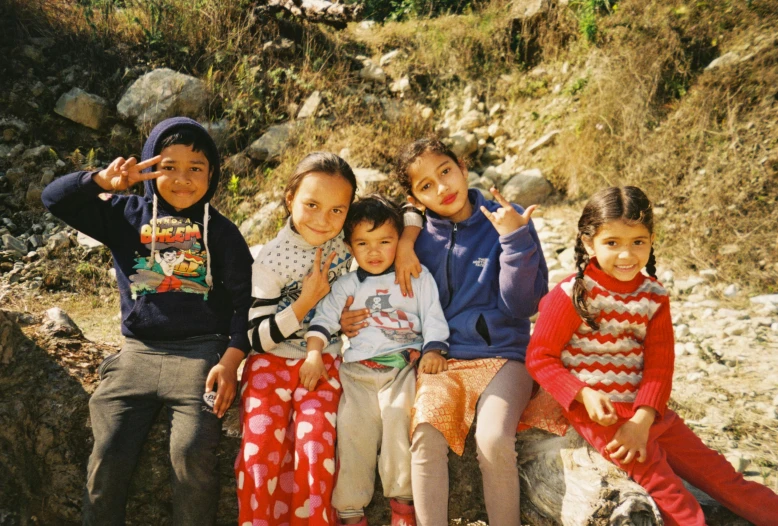 a group of s sitting together on top of a stone