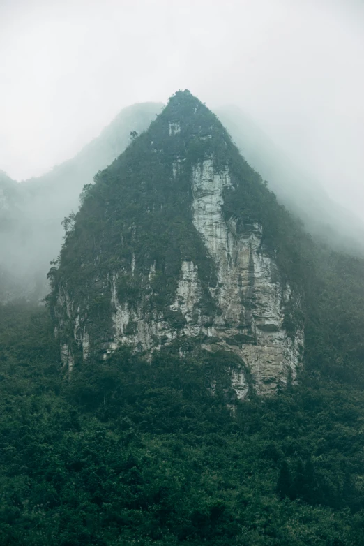 a rock outcropping on top of a hill in the middle of a jungle