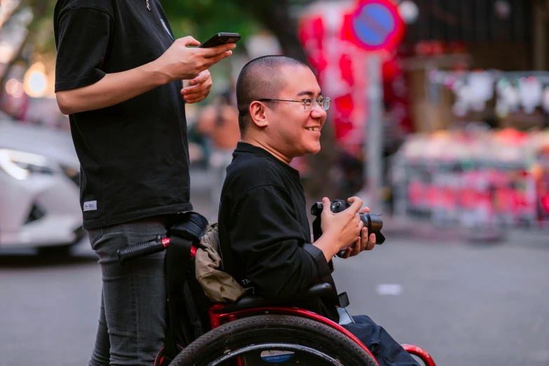 a man in a wheel chair using a cell phone