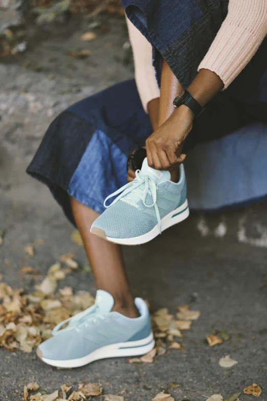 a person tying up a sneaker on the street