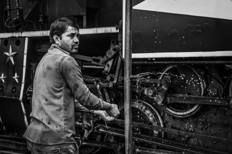 black and white po of a man working on an engine