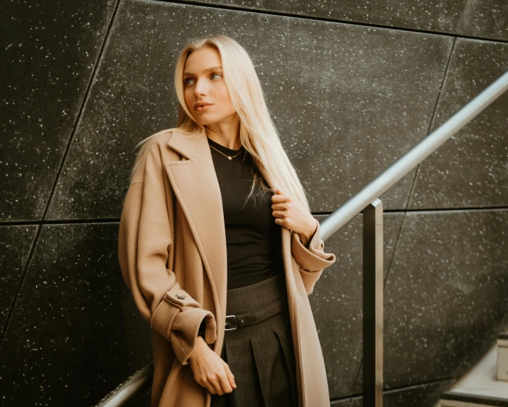 a blonde woman posing on the steps outside