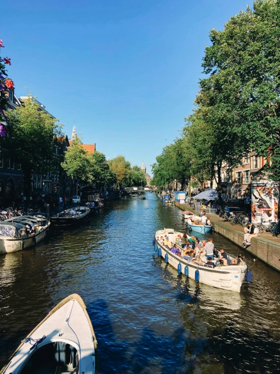 people sitting on boats along a river