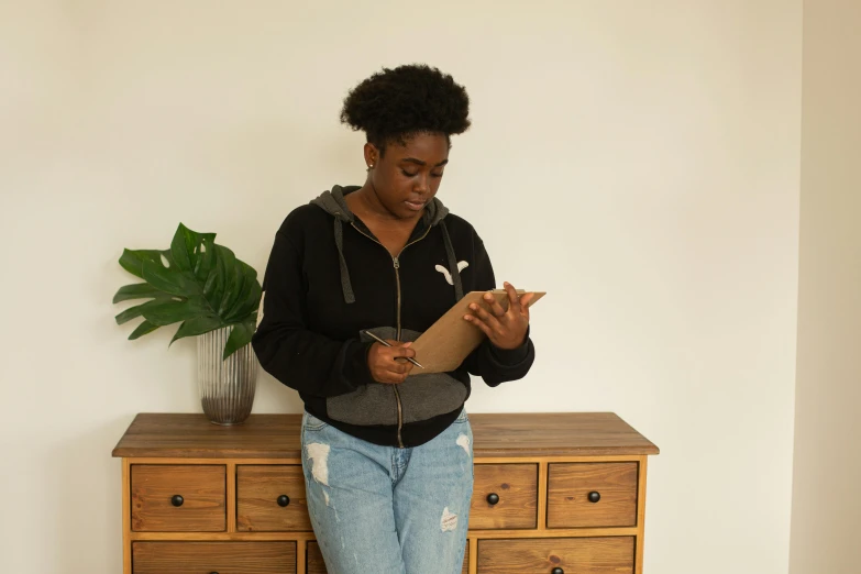 a woman looks at her phone while standing on top of a dresser