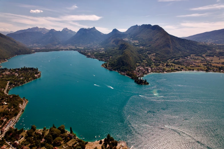 a lake sits next to mountains, with houses on the shore