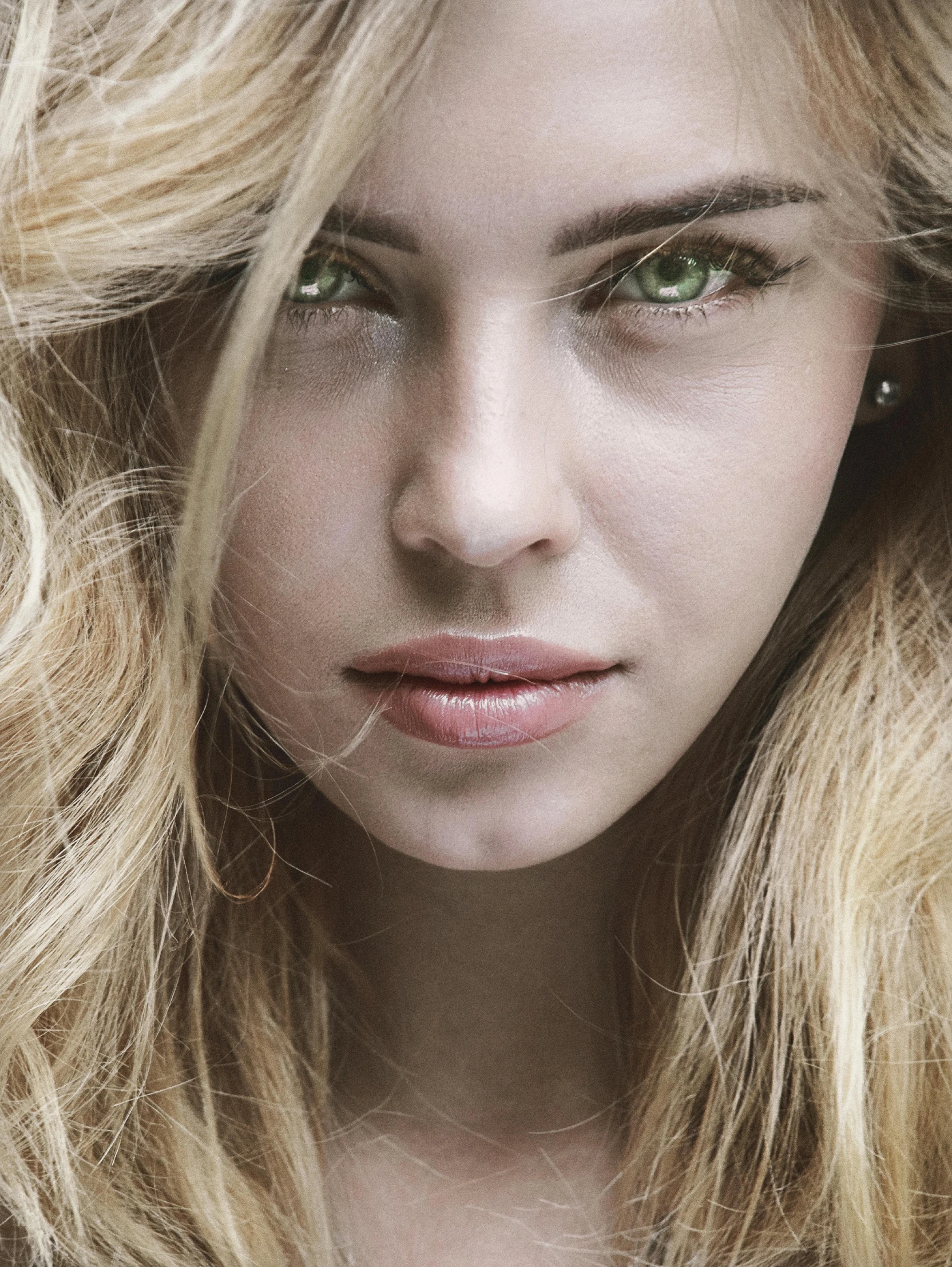 a beautiful blonde girl is posing with her hair