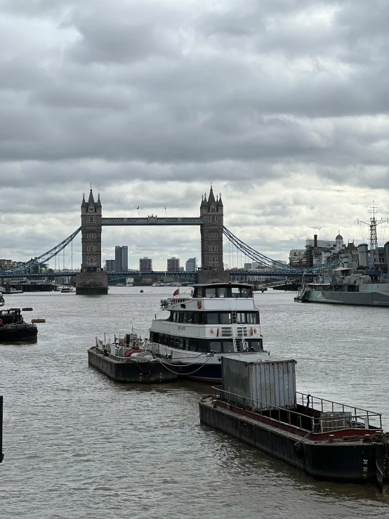 boats traveling down the river under an over pass bridge