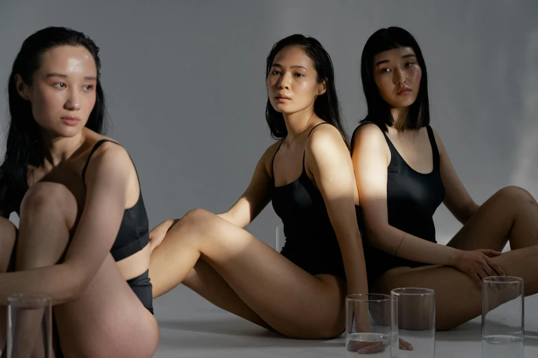 three women sitting on a table and looking at the camera