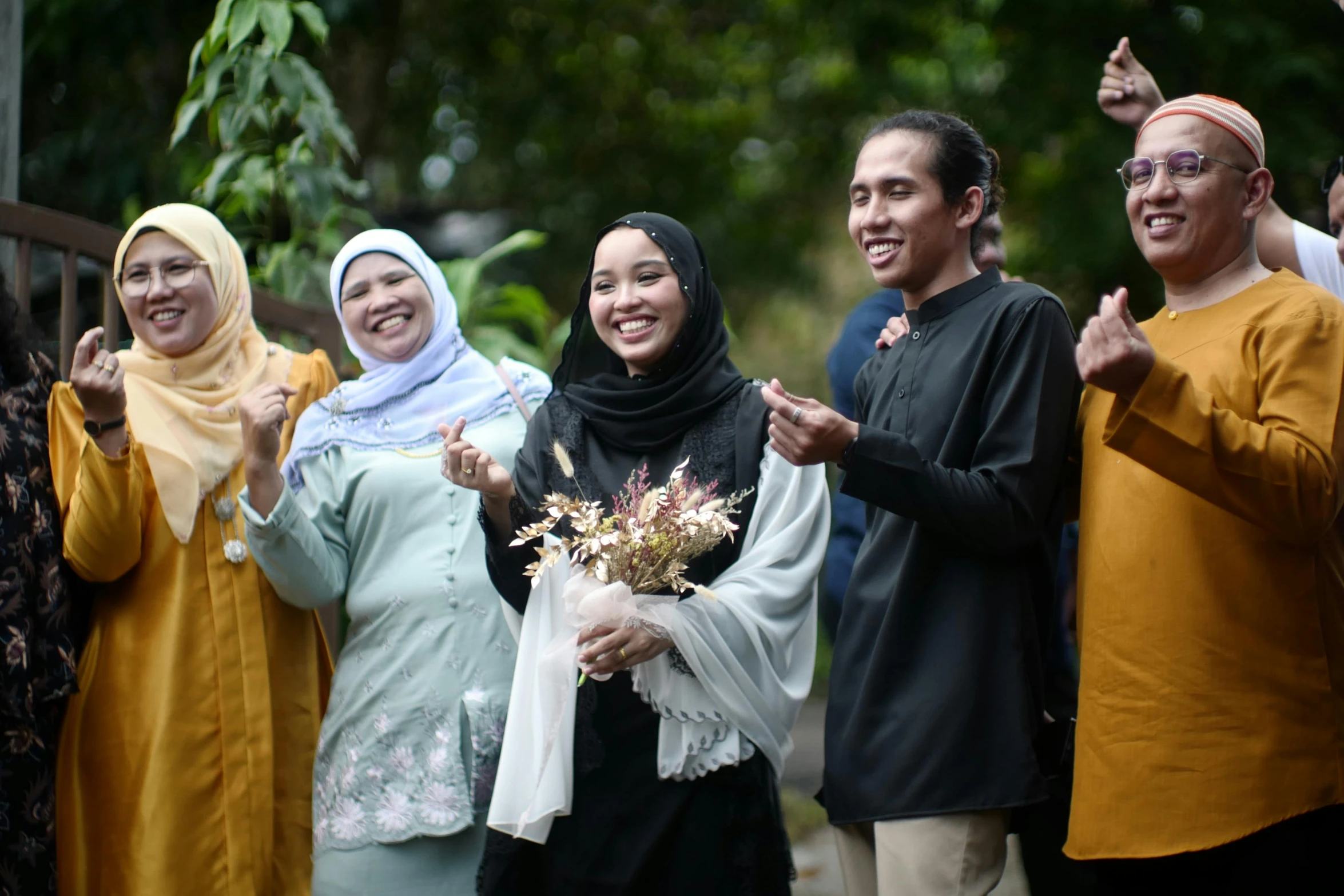 group of people giving the peace sign with their hands