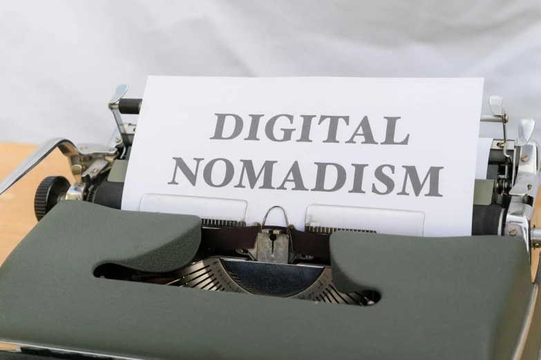 a white paper on top of a typewriter that is reading digital nomadism