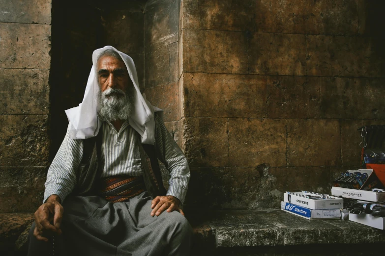 an old man sitting on a step in front of a building