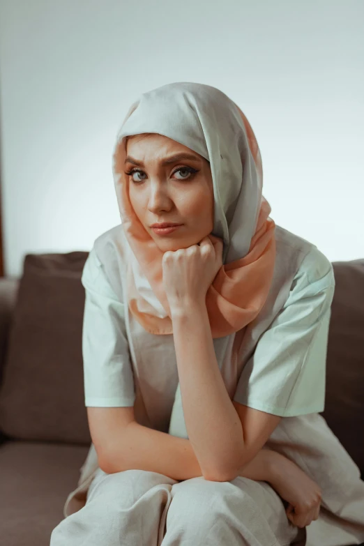 a lady with a headscarf on sitting in a couch