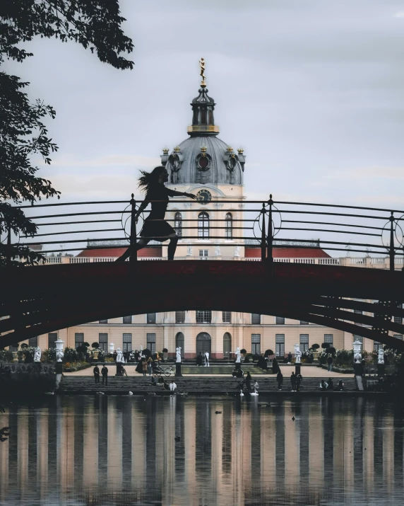 the person is walking on the bridge over the water