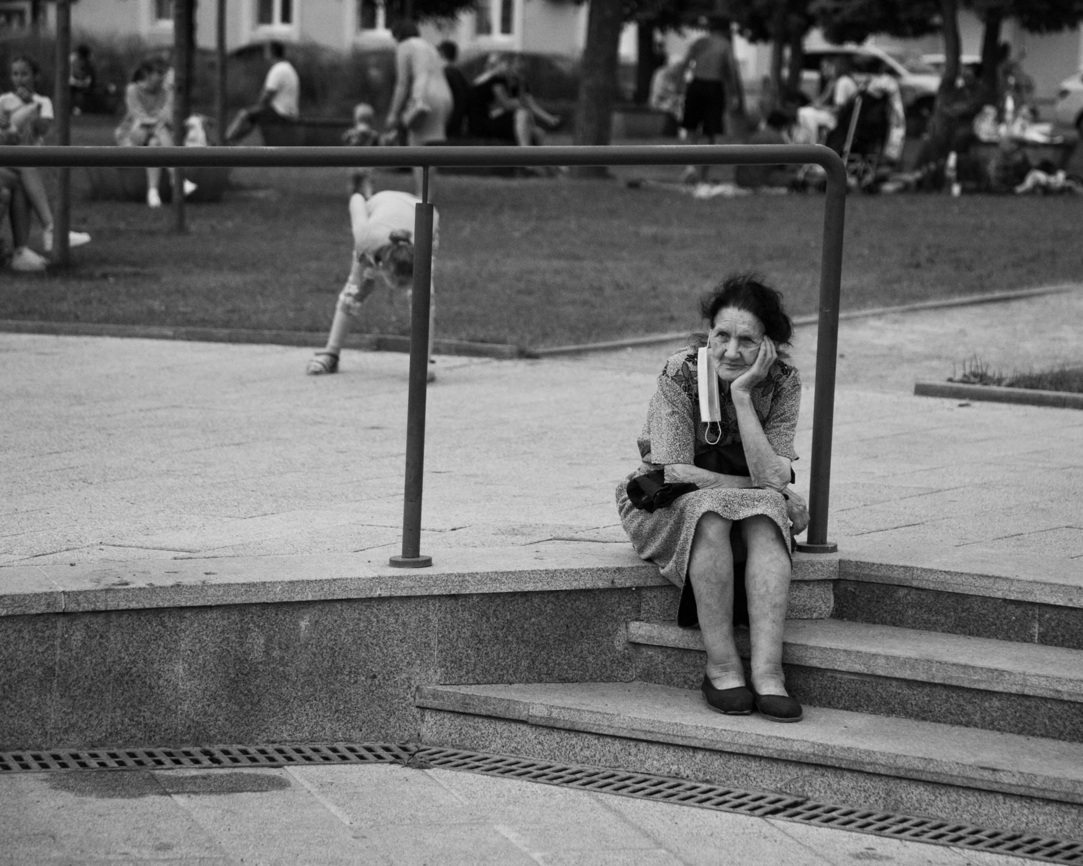 an older woman sitting on the steps outside