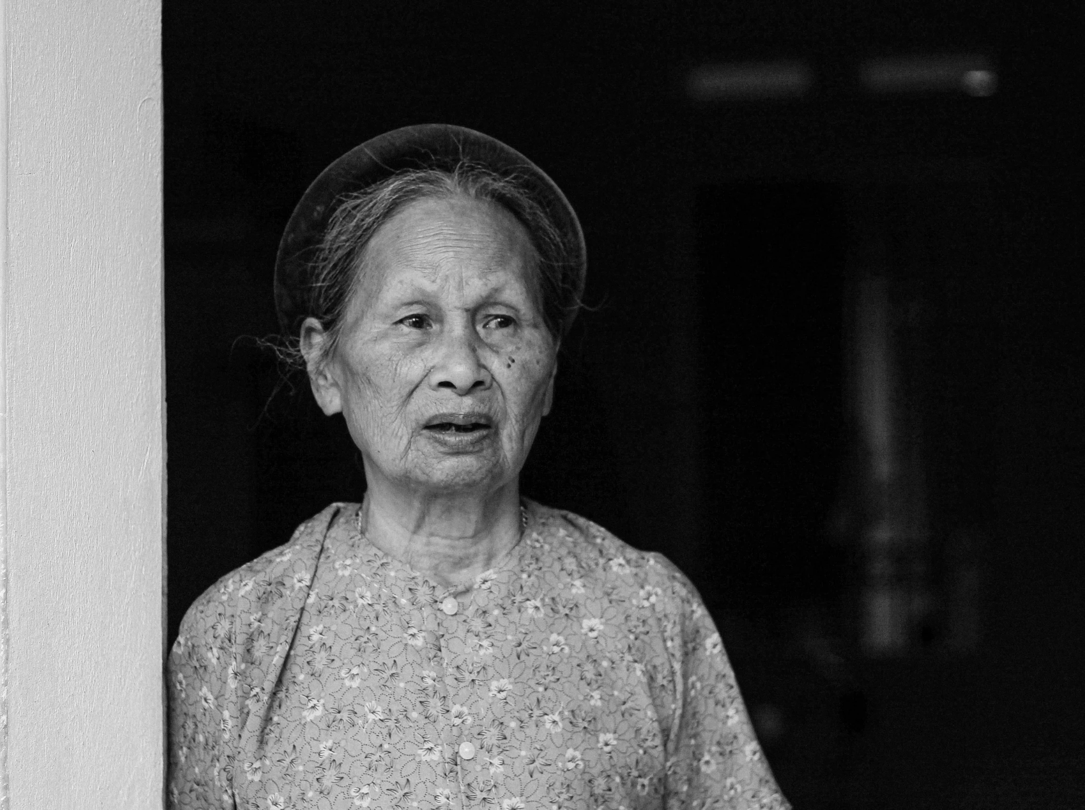 an old woman standing in front of a door
